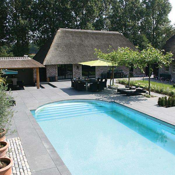 Landelijke woning met afgerond zwembad met maatwerk terras in natuursteen